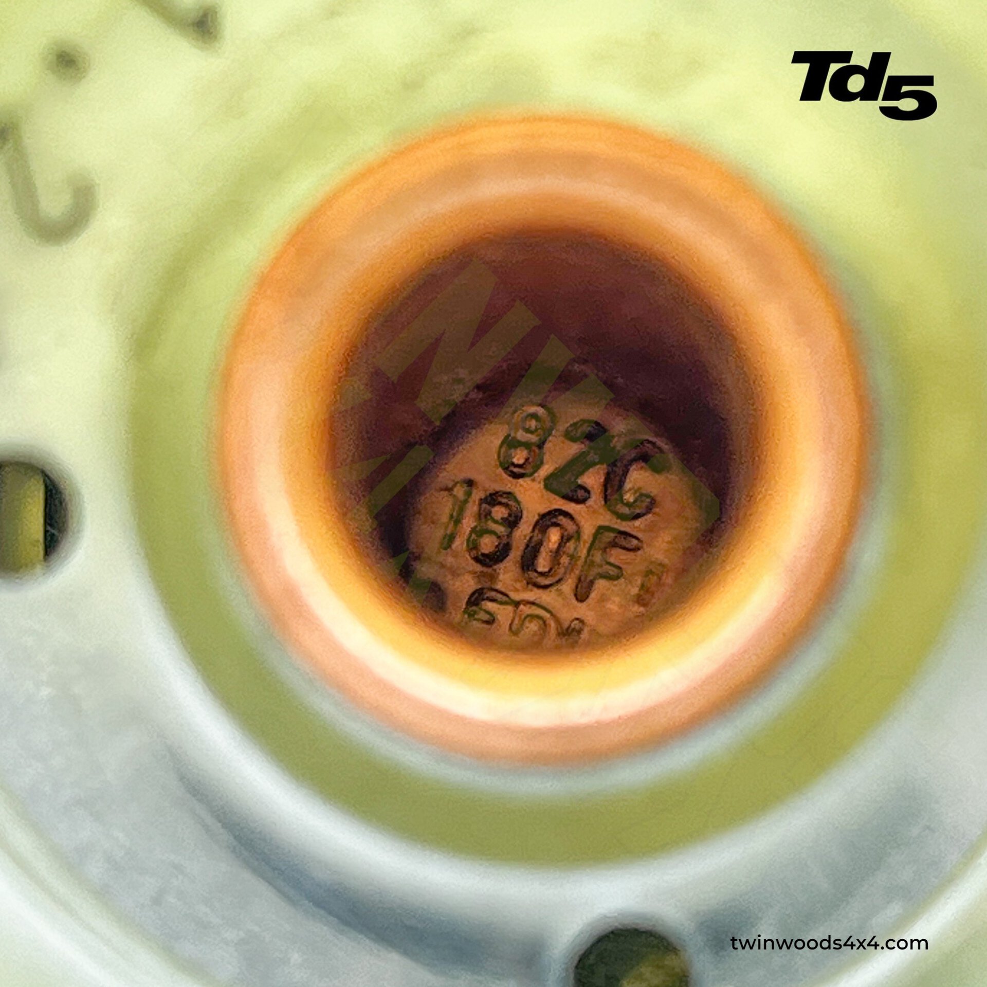 Td5 Thermostat Guide: Operation, Temperature Specs & Fault Symptoms Close-up of Land Rover Td5 thermostat internal wax capsule showing the 82C and 180F temperature stamp markings